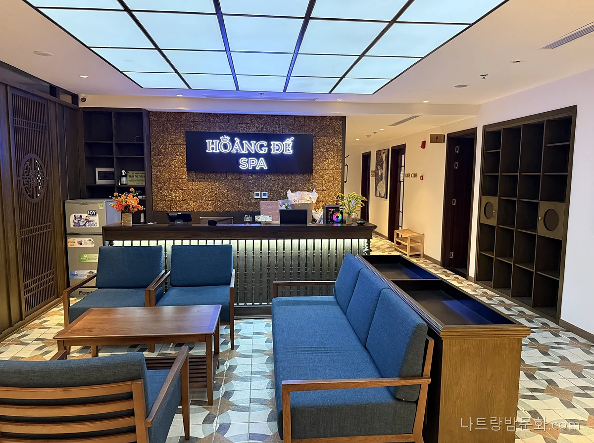 나트랑 황제스파 접수대와 HOÀNG ĐẾ SPA 간판, 파란 소파가 놓인 대기 공간