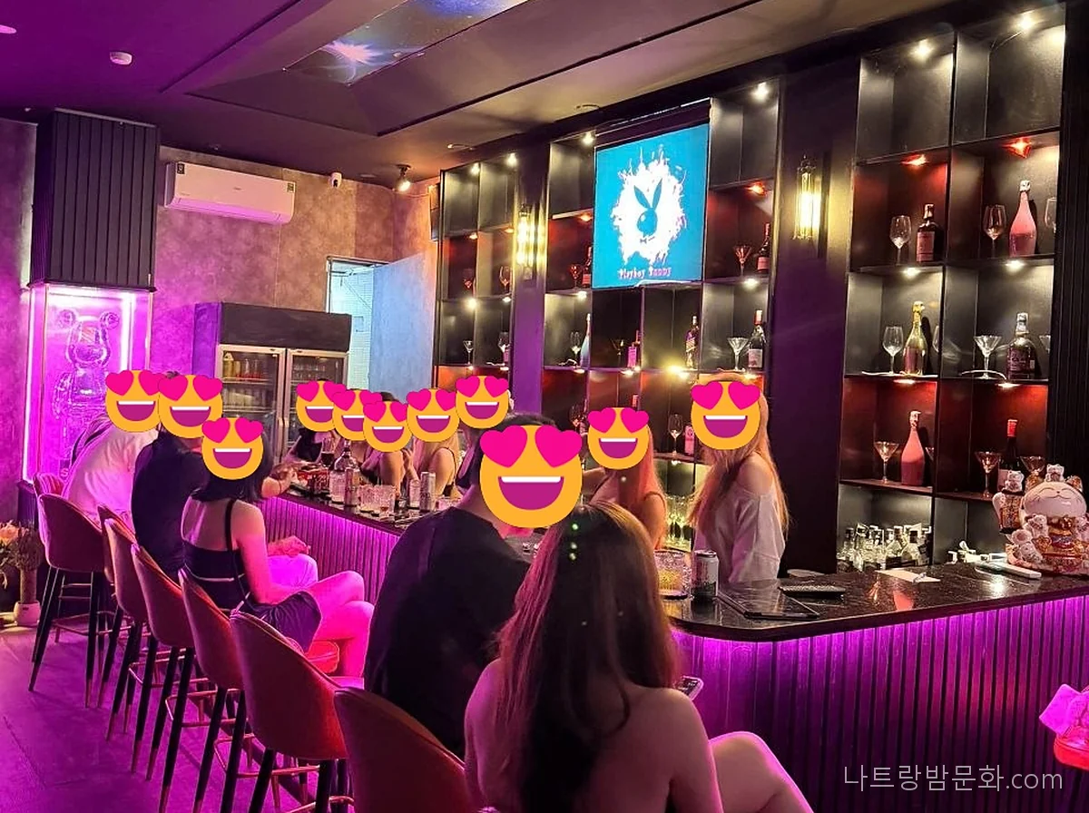 나트랑 버니바 바 카운터와 높은 의자, 네온 조명 내부 사진(얼굴은 이모지로 가림)